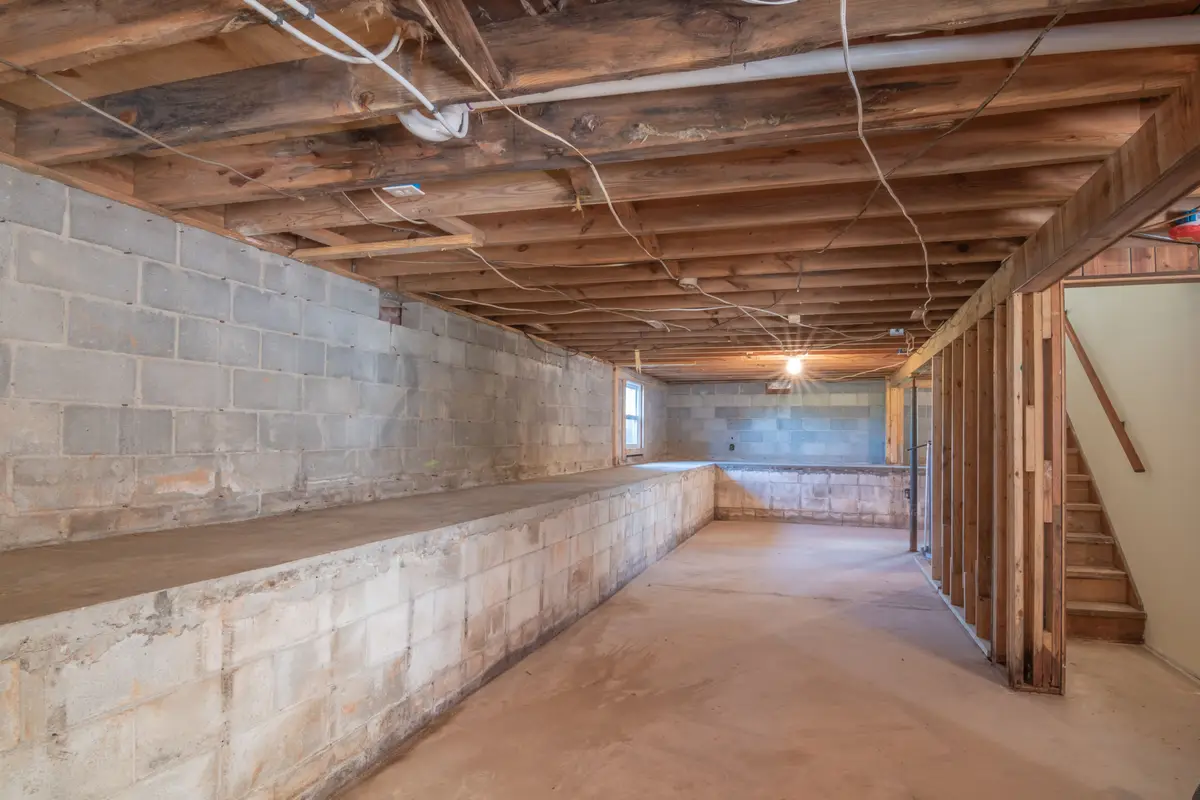 An unfinished Iowa basement with concrete-block foundation walls, an exposed slab, and a visible floor-wall joint.